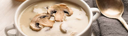 White bowl of mushroom soup on a white wooden background banner.の写真素材