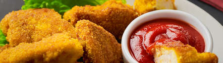 Close up fried chicken nuggets with ketchup panoramic banner.