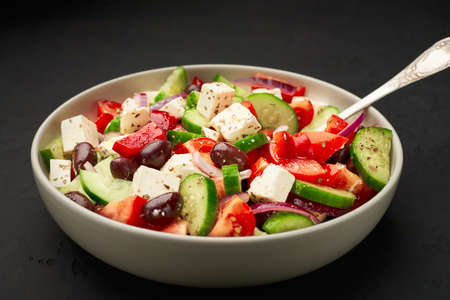 A big bowl of classic Greek salad on dark background.の写真素材