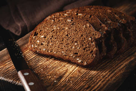 Slices of rye bread with sunflower seeds on a cutting boardの写真素材
