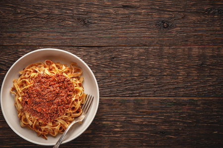 Pasta tagliatelle with BOLOGNESE SAUCE on wooden rustic background with copy spaceの写真素材