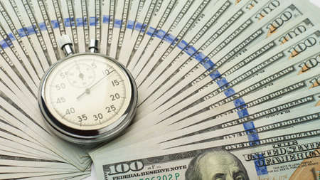 Stopwatch and one hundred dollar bills, time is money conceptの写真素材