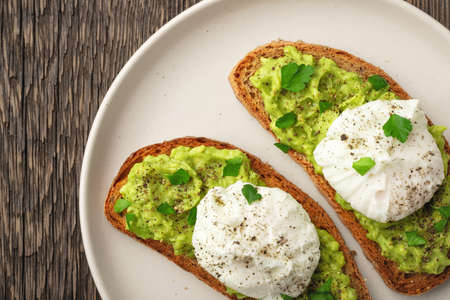 Top view avocado toast with poached egg in plateの写真素材