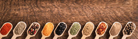 Various spices in wooden spoons top view with copy space bannerの写真素材