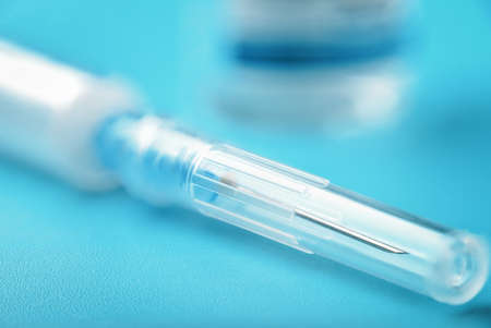Close up syringe and ampoule on blue background