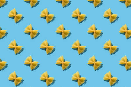Pasta farfalle repeating seamless pattern on blue backdropの写真素材
