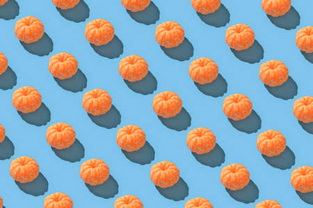 Peeled mandarin repeated seamless pattern on blue backdrop