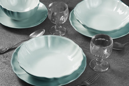 Empty plates and glasses for two people. Studio shot from a high angle.