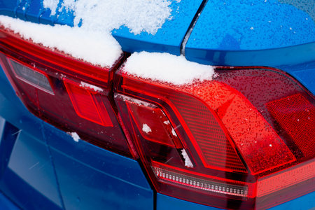 Close-up of red tail lights of a modern car in the winter season.の写真素材