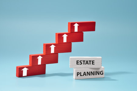 Stacked wood blocks represent the steps in the estate planning process, highlighting growth and success in securing financial futures against a blue background.の写真素材