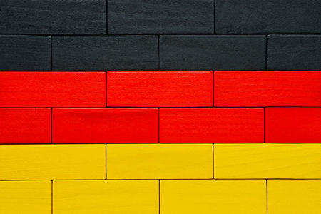 Wooden blocks are stacked in the German flag pattern with black, red, and yellow colors.の写真素材