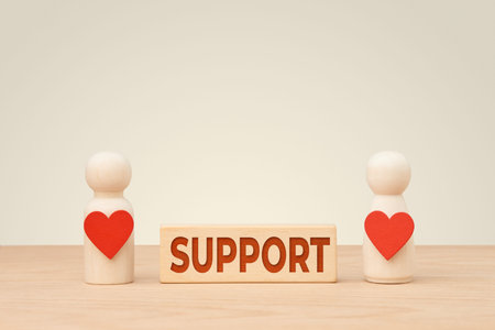 Wooden couple with hearts and support concept block