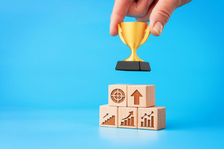 Career growth concept: hand placing trophy on pyramid, copy space left