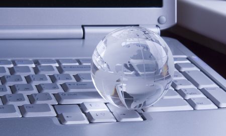 Crystal-glass globe on keyboard of  modern notebook. Backgroundの写真素材
