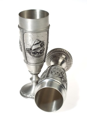 Two metal souvenir wine goblets over white background