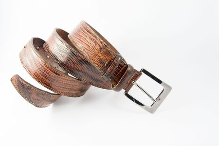 Brown leather belt with chrome-plated buckle on whiteの写真素材