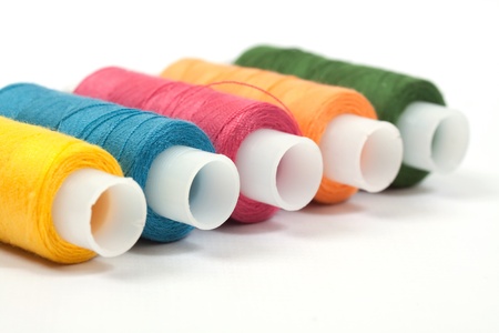 Color thread reels over white background. Selective focus