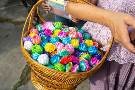 almsgiving with alms flowers (ribbon-flowers) for giving alms to make merit in Buddhism religious traditional in Thailand.の写真素材