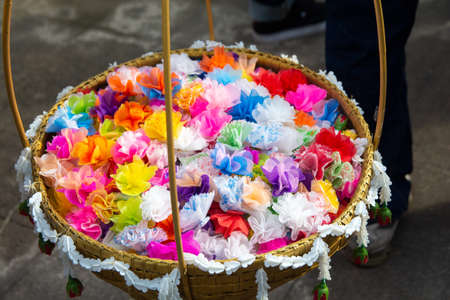 almsgiving with alms flowers (ribbon-flowers) for giving alms to make merit in Buddhism religious traditional in Thailand.の写真素材