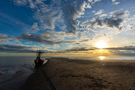 Beautiful sunrise above sea or ocean and small clouds on the sky, reflection of sun in the water and...