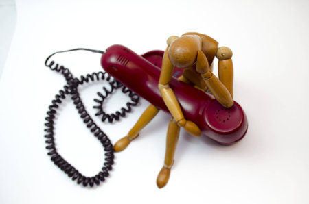 wood mannequin sitting waiting callの写真素材