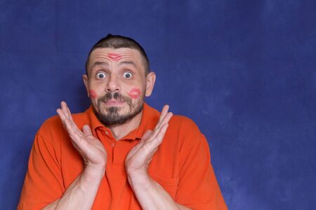 A man aged 40-45 years. Man in lipstick. Traces of kisses on the face. Valentine's Day.の写真素材