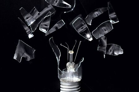 Broken incandescent lamp. Glass shards. The glass shatters to the sides. The sharp edges of the...