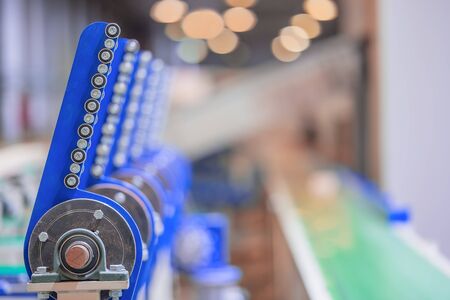 Industrial equipment. close-up photo. Refocused background. Green conveyor belt.