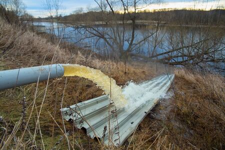 Industrial waste is discharged into the river. Ecology concept.の写真素材