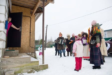 Russia. Tver region Village "White outside." January 7, 2020. Caroling in the village. National holidays and customs. A woman looks at caroling people.のeditorial素材