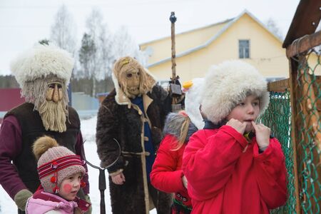 Russia. Tver region Village "White outside." January 7, 2020. Caroling in the village. National holidays and customs. A little boy whistles near the fence.のeditorial素材