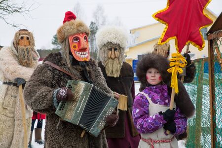Russia. Tver region Village "White outside." January 7, 2020. Caroling in the village. National holidays and customs. A stuffed goat in the foreground. Masked mummers in the background.のeditorial素材