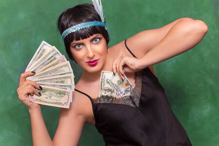 Beautiful woman holding dollar bills. Green background. retro style woman.