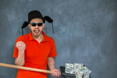 Brutal man holds dollar bills on a shovel. The concept of a successful business.