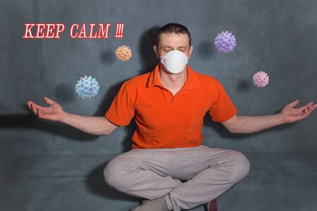 Man with a medical mask in a meditation pose. The covid-19 virus flies in the air. Caption: "Keep calm." Prevention of fear of covid-19.の写真素材