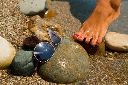 Women's feet in sea water. Sea vacation concept.