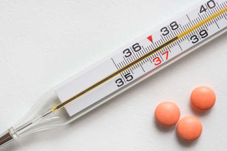 A medical thermometer shows a temperature of 38 degrees. Viral disease concept.の写真素材