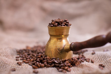 Coffee beans are poured into the coffee maker. A photo with a shallow depth of field. Selective...
