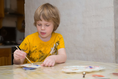 Children paint with paints and colored sand in a village house. Children are busy with creativity.の写真素材