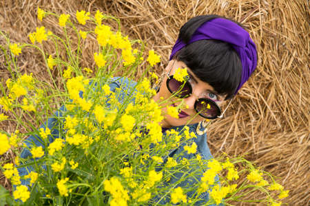 European woman with yellow flowers in nature.