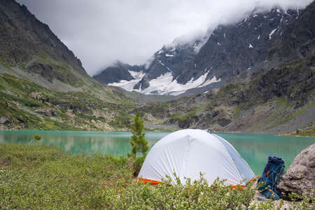 A tourist tent stands in the mountains near the lake.の写真素材