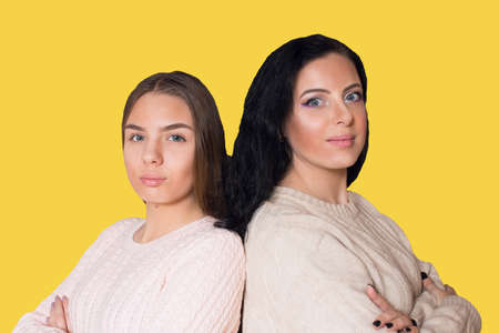 A woman with black hair next to a young girl. Mom is next to her daughter.の写真素材