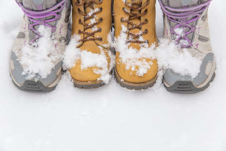Two pairs of boots stand in the snow. Snow lies on the boots. Cooling and snowfall concept. Snowy weather.の写真素材