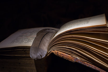 Old book with open pages. Dark background. The concept of mysticism and secret knowledge, esotericism. Selective focus on the pages of the book.の写真素材