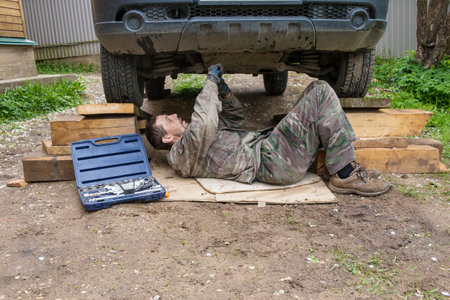 A 45-year-old European man is repairing an old car.の写真素材
