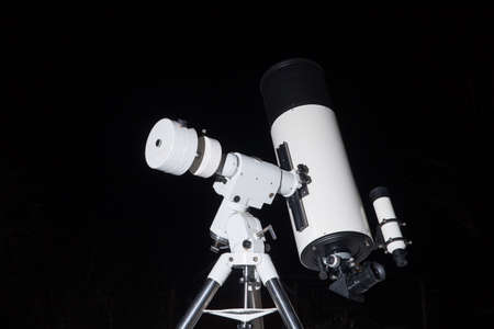 Photo of a telescope on a black background.