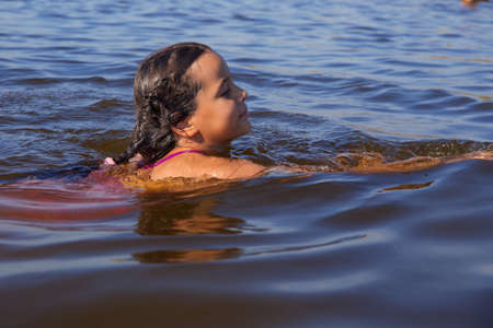 The European girl is swimming in the water.の写真素材