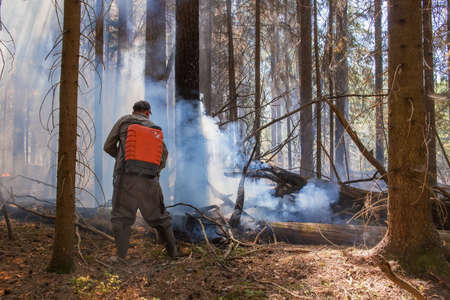 June 23, 2021. Russia. Tver region. Forest worker extinguishes a fire in the forest.