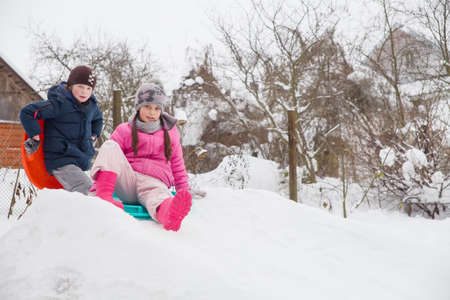Children ride from a snow slide on ice floes.