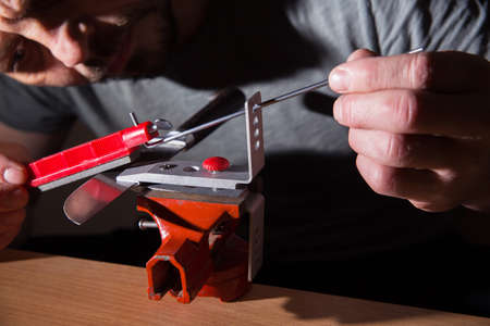 The man is sharpening a knife.